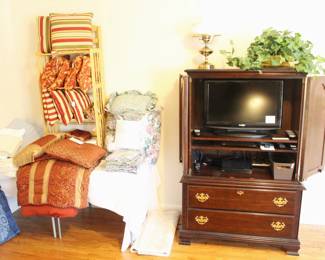 Comforters, decorator pillows, TV inside cabinet.