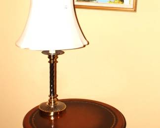 Leather top round table, lamp and framed picture.