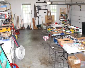 Garage is full of a variety of tools and garden items.
