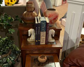 Hand carved nesting tables, marble book ends, books, pottery