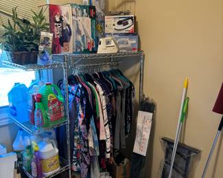 Wire rack shelving with wheels, clothes, cleaning supplies