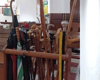 Huge lot of walking canes and umbrellas with umbrella stand