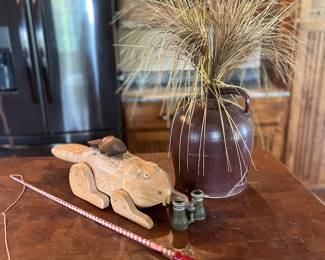 Carved groundhog, binoculars, crock