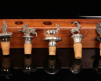 Sterling silver bottle stoppers in wooden rack