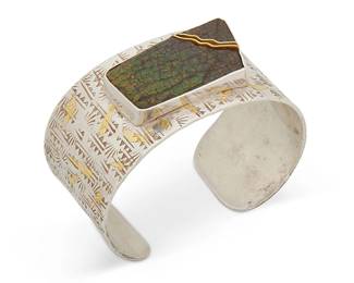 2025
A Sterling Silver And Set Stone Cuff Bracelet
Late 20th/21st century
Unmarked
A stamped silver band cuff with central set ammolite and gold accents
6.625" inner C x 1.375" H, with a 1" gap
79.0 grams gross
Estimate: $500 - $700