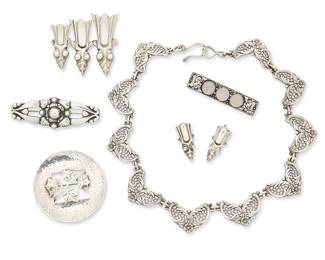 2203
A Group Of Silver Jewelry
Mid/late 20th century
Three marked for maker; five marked for sterling
Six works comprising a Danecraft sterling silver filigree link necklace, a Danish style sterling silver floral brooch, a Leonore Doskow hammered sterling silver disc brooch with ivy, as well as a sterling silver "croesus beetle" insect motif brooch with a matching pair of earrings, and an unmarked silver metal brooch with three set clear stones, 7 pieces
Necklace: 17" L x 0.875" H; Brooches: 2" H x 2.25 "W; 1" H x 2.75" W; 2.125" Dia.; 0.5" H x 2.25" W; each earring: 1.25" H
119.0 grams gross
Estimate: $400 - $600