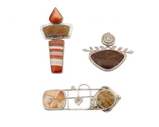 2157
A Group Of Stone-Set Jewelry
Late 20th/21st century
One marked for maker and for sterling
Three works comprising an Echo and the Dreamer sterling silver pendant/brooch, with peach moonstone, banded agate, and set drusy, as well as two unmarked sterling silver Cassandra brooches with various set stones, 3 pieces
Pendant: 2.5" H x 1.25" W; brooches: 1" H x 2.875" W and 1.5" H x 2" W
44.9 grams gross
Estimate: $300 - $500