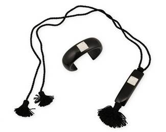 2074
A Set Of Lalique Arethuse "Masque De Femme" Jewelry
Late 20th century, France
Each marked: Lalique
Two works comprising a Lalique black resin pendant necklace with inset carved glass "Arethuse" face, suspended on a black tasseled cord, together with a matching black resin cuff bracelet, also with inset carved glass "Arethuse" face, 2 pieces
Necklace: 37" L x 4.25" H; cuff: 6.5" inner C x 0.875" H, with a 1.25" gap
Estimate: $500 - $700