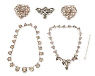 2172
A Group Of Vintage Silver Jewelry
Early/mid-20th century
One marked for maker; two marked for sterling; three unmarked
Five works comprising a sterling silver Art Nouveau-style iris brooch, a sterling silver Fratelli Peruzzi grape motif necklace as well as a silver "mascharone" mask motif necklace, and a pair of "grotesque" mask motif brooches with elaborate openwork, and a contemporary necklace extender, 6 pieces
Necklaces: 15.75" L and 14.5" L; largest brooch: 2.125" H x 2.25" W; smallest: 1.75" H x 2.125" W
114.2 grams gross
Estimate: $700 - $1,000
