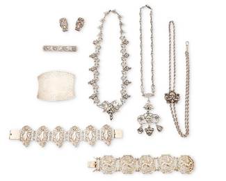 2174
A Group Of Vintage Silver Jewelry
Early/mid-20th century
Four marked for maker; five marked for sterling ; three marked for 800 silver
Eight works comprising a sterling silver Peruzzi Italian grape motif necklace, an Italian silver "grotesque" masks pendant necklace with dangles, and a sterling silver watch chain with ornate slide, as well as two silver repoussé and openwork link bracelets, one by Coppini, and a large chased silver buckle-style brooch, a grape motif bar brooch and a pair of Unger sterling silver collar clips one with a ruby, 9 pieces
Largest necklace: 17.25" L; smallest: 15" L; brooches: 2.25" H x 2.875" W and 0.5" H x 2" W; bracelets: 7.5" L x 1.5" H and 7" L x 1.25" H; each collar clip: 1" H
217.2 grams gross
Estimate: $1,000 - $1,500
