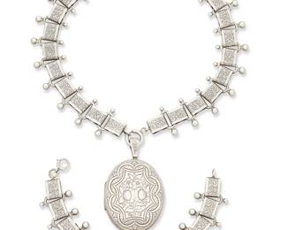 2078
A Set Of Danecraft Sterling Silver Jewelry
Mid-20th century
Each stamped: Danecraft / Sterling
Two works comprising a large chased silver oval locket suspended on a chased sterling silver link book chain with silver ball accents, and a matching bracelet, 2 pieces
Necklace: 15" L; locket including bail: 2.5" H x 1.5" W; bracelet: 7.875" L x 0.875" H
102.1 grams
Estimate: $300 - $500