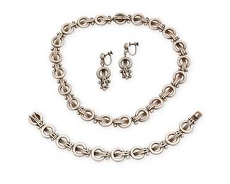 2090
A Set Of Hector Aguilar Mexican Silver Jewelry
Hector Aguilar (1905-1986)
Circa 1953-1962; Taxco, Mexico
Each stamped: HA [conjoined] / Taxco / 940 / [Eagle 9]
Three works comprising a necklace of circular links and wire elements, a matching bracelet and a pair of matching screw-back earrings with dangles, 4 pieces
Necklace: 15.5" L x 0.5" H; bracelet: 7.5" L x 0.5" H; each earring: 1.5" H
133.7 grams
Estimate: $600 - $800