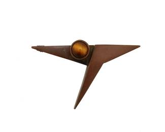 2033
A Peter Macchiarini Mixed-Metal Brooch
Peter Macchiarini (1909-2001)
Circa 1960s, San Francisco, CA
Unmarked
An asymmetrical bronze-colored metal stone-set brooch with tapered abstract "Y" design and tiger's eye cabochon
1.625" H x 2.5" W
15.0 grams gross
Estimate: $800 - $1,200