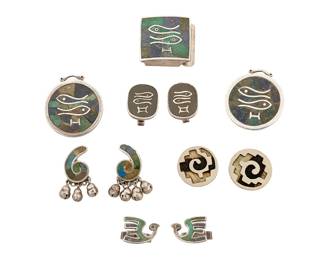 2186
A Group Of Los Castillo Mexican Silver Jewelry
Circa 1948-1965; Taxco, Mexico
Each stamped: Los Castillo; further variously stamped: Taxco / Sterling / Made in Mexico / [Eagle 15] / Silver / Mosaico Azteca / Onix Negro / [design numbers: 114, 262]
Seven works in sterling silver and stone inlay comprising three Mosaico Azteca items including two disc pendant/brooches and a square belt buckle, each with a Pisces Zodiac symbol, as well as a pair of Pisces "Onix Negro" inlay cuff links, together with a pair of green stone inlay earrings with bell dangles, and two pairs of cuff links, one with inset feathers in black and white, and one pair in a bird motif and stone inlay, 11 pieces
150.5 grams gross
Estimate: $200 - $400
