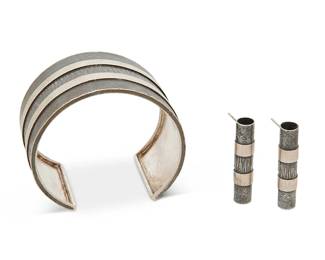 2027
A Set Of Sterling Silver Davide Bigazzi Jewelry
Late 20th/21st century
Each stamped: Davide Bigazzi / .925
Two works comprising a chunky cuff bracelet with alternating bands of oxidized and brushed silver textures, together with a pair of matching cylindrical earrings, 3 pieces
Cuff: 7.5" inner C x 1.625" H, with a 1.375" gap, each earring: 1.5" H
68.4 grams
Estimate: $400 - $600