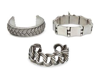 2063
A Group Of Hector Aguilar Mexican Silver Bracelets
Hector Aguilar (1905-1986)
Circa 1940-1945; Taxco, Mexico
Each stamped: HA / Taxco / 940
Comprising three sterling silver bracelets including a cuff with an interlaced twisted wire chain motif, a chunky cuff with braided overlay motif and rope edging , and a link bracelet with a triple ball and concave link design, 3 pieces
Largest cuff: 7" inner C x 0.75" H; smallest: 6.25" inner C x 1" H; link bracelet: 7.5" L x 0.75" H
238.4 grams
Estimate: $1,000 - $1,500