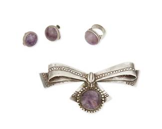 2143
A Group Of William Spratling Silver And Amethyst Jewelry
William Spratling (1900-1967)
Circa 1940-1944; First Design Period; Taxco, Mexico
Each stamped for William Spratling; further stamped: Made in Mexico / Silver
Three works in sterling silver with set amethyst cabochons comprising a bow brooch, a chunky stone-set ring, and a pair of earclips, 4 pieces
Brooch: 2.25" H x 4.375" W; ring: size: 4.25; 0.75" Dia.; each earclip 0.75" Dia.
74.8 grams gross
Estimate: $500 - $700