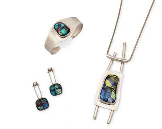 2117
A Group Of Sterling Silver And Dichroic Glass Jewelry
Late 20th/21st century
Each marked for sterling; two marked for maker
Three works comprising a large HM modernist sterling silver and dichroic glass pendant necklace on a snake chain, a sterling silver cuff bracelet with central set dichroic glass cabochon, and a pair of Orly Lindsay silver and dichroic glass earrings, 5 pieces
Necklace: 26" L x 4.625" H x 1.25" W; cuff: 6.25" inner C x 1.125" H, with a 0.875" gap; earrings: 1.5" H
74.9 grams gross
Estimate: $400 - $600