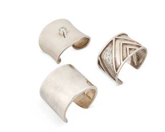 2126
A Group Of Sterling Silver Cuff Bracelets
Late 20th/21st century
Three marked for maker and for sterling
Three works comprising a Jane Bohan modernist silver cuff with a wide textured band of wave motifs, as well as a Mexican silver cuff with central set gemstone, and a Lico Mexican silver cuff with chevron design overlay and etched details, 3 pieces
Largest: 7" inner C x 2.125" H, with a 1.375" gap; smallest: 6.25" inner C x 2.375" H, with a 1.125" gap
195.3 grams gross
Estimate: $200 - $400