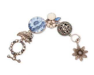 2107
A Mars And Valentine Floral Link Bracelet
Late 20th century
Marked with artists cipher: M [within a heart]; further marked: Sterling
A chunky sterling silver bracelet with various set floral ceramic, metal, gemstone and pearl links with a large floral charm
8.5" L x 1.5" H
91.7 grams gross
Estimate: $300 - $500