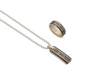 2002
A Set Of Tiffany & Co. "Atlas" Sterling Silver And Titanium Jewelry
Late 20th/21st century
Each stamped: © / Tiffany & Co. / 925; ring and pendant further stamped: Ti / Atlas
A set of "Atlas" jewelry, including a pendant necklace with Roman numerals and dark edging, on a sterling silver ball chain, and a matching ring band, 3 pieces
Necklace: 20" L x 1.625" H; ring: size 13.5
28.8 grams gross
Estimate: $500 - $700