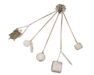 2224
A Vintage Sterling Silver Chatelaine Belt Clip
Late 19th/early 20th century
Clip and other pieces variously stamped with British and Continental hallmarks including a crown, lion rampant, anchor (Birmingham); further stamped: Sterling / 4489
A constructed piece designed with multiple chased silver vintage and antique silver items suspended from an Art Nouveau-style repoussé buckle/clip of intertwined sea serpents, including a pocket watch case, a small box (Birmingham, 1908), a powder compact, a mechanical pencil, two pocket knives, and a small chain mail purse, some with monograms
17" l x 4.5 " W approximately; clip: 2.5" H x 2.5" W
278.1 grams gross
Estimate: $400 - $600
