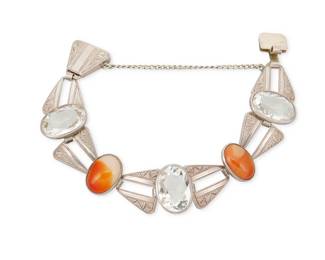 2069
A Japanese Sterling Silver And Set Stone Link Bracelet
20th century
Stamped: Inoue / Tokyo / Silver / CPO [within triangle]
An Art Deco-style bracelet with triangular openwork chased silver links alternating with set quartz and carnelian cabochons
7.25" L x 0.875" H
37.4 grams gross
Estimate: $300 - $500