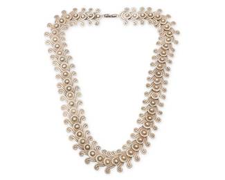 2076
A Los Castillo Mexican Silver Necklace
Circa 1940-1945; Taxco, Mexico
Stamped: Los Castillo / Taxco / Sterling / Made in Mexico / 262 [design number]
An elaborate scrolled line-and-dot wave form sterling silver link necklace
25" L x 1.25" W
153.6 grams
Estimate: $800 - $1,200