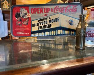 Cardboard coke sign in metal stand