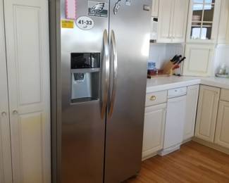 Frigidaire side-by-side refrigerator with beverage dispenser. Fridge is 69 inches tall x 35 5/8 inches wide  x 28" deep