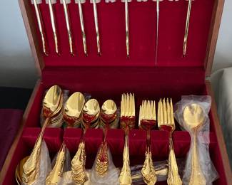 Gold color flatware set in wood box.