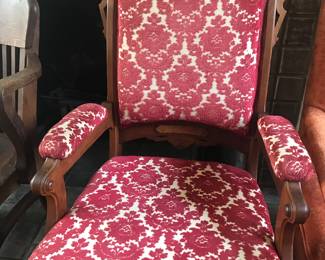 Antique arm chair in pretty red patterned fabric.
