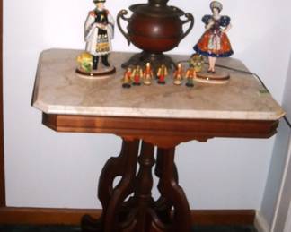 A pair of Hungarian dancing figurines pose on either side of a fine old lamp.  All this, and another very nice old marbletop table.