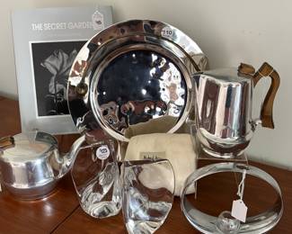 Shown are a Beautiful 13" Michael Aram Platter, Daum Book Ends, a Vintage Nambe Circle Vase and Vintage Picquot Ware Aluminum Coffee Pot and Tea Pot with Sycamore Wood Handles