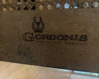 Gordon’ furniture label that is on the gold, glass and wood side table. 