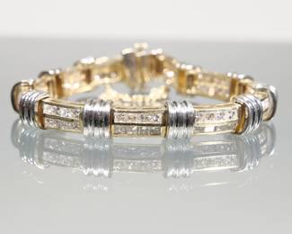 DIAMOND & 14K GOLD LINK BRACELET | Designed as links of (tested to) 14k yellow gold mounting double-lines of channel-set diamonds alternating with links of 14k white gold; no apparent makers mark or fineness mark; 23.5g.

