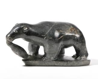 INUIT CARVED STONE BEAR | Carved stone figure of a bear with Canada Eskimo Art and Povungnituk label identifying artist on bottom - l. 11 x w. 4.5 x h. 4.5 in.

