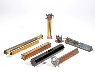 (6pc) GLASS & BRASS KALEIDOSCOPES | Including a Sue Ross hammered pewter and stained glass kaleidoscope, a hand-crafted slag glass kaleidoscope signed "Papillon", a black glass hexagonal kaleidoscope signed :J. Falandysz" and dated 1986, an orange and green slag glass kaleidoscope signed and dated "Peter G Roberts 86 # 52", a Corki Weeks engraved brass kaleidoscope with original plastic wrap and label, and a small brass and copper kaleidoscope unsigned - l. 12.5 x dia. 1.25 in. (Corki Weeks)
