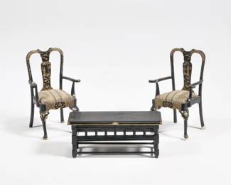 (3pc) MINIATURE CHINOISERIE SUITE | Dollhouse miniature suite comprising a pair of armchairs and a matching low table, the chairs decorated in gilt chinoiserie scenes and patterns on black "lacquer" paint; no apparent signature - l. 3.5 x w. 1.5 x h. 1.25 in. (table)