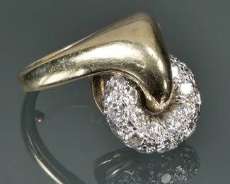 DIAMOND, PLATINUM, & 14K GOLD SPINNER RING | Designed as an articulating platinum donut,-form wheel mounting melee diamonds, supported en tremblant from a gold axle frame, with maker's mark and stamped 14k inside the band; size 4-5, 13.1g

