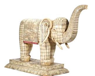 MONUMENTAL INDIAN/CHINESE CARVED BONE ELEPHANT | Decorated with a mosaic patchwork of carved bone, the elephant with trunk raised and wearing a decorative textile with a sinuous carved dragon among clouds - l. 31 x w. 16.25 x h. 34 in. (overall)
