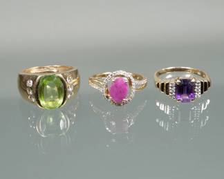 (3pc) 14K GOLD & GEMSTONE RINGS | Including an oval mixed cut green stone (11.8mm long) set with six small full cut diamonds (size 5.75, 8.1g) marked "14k"; a ring with a square cut amethyst (8.6mm long) set with melee diamonds (size 6, 3.2g) marked "14k / A"; and probably natural ruby/ pink sapphire (8.1 x 6 x 3.7 mm) with lines of melee diamonds (size 5.75, 3.1g) marked "14k" 

