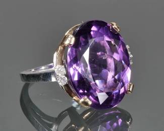OVAL CUT AMETHYST, DIAMOND & 14K GOLD RING | Designed as a central oval mixed cut amethyst (22 x 17.1 x 10.8mm) prong-set in a yellow gold gallery and flanked by four prong-set melee diamonds in a (tested to) 14k white gold ring; size 4.75, 10.0g total weight; no apparent markings.

