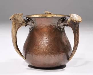JOHN FRICK, NY HAMMERED COPPER ARTS & CRAFTS LOVING CUP | Designed as hammered, copper and silver mounting three antler handles; marked on the bottom, "copper and silver/John Frick Jewelry Co. N.Y." - l. 8 x w. 8 x h. 6 in.
