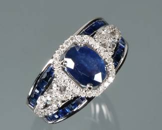 EFFY SAPPHIRE, DIAMOND, & 14K WHITE GOLD RING | Designed as a central oval mixed cut natural sapphire (8.25 x 5.8 x 2.5 mm), prong set and surrounded by a geometric border of prong set melee diamonds, the shoulders decorated with four lines of channel set square cut sapphires; marked "14K" and with faded name "- - E F Y" on interior; size 5.75, 5.8g
