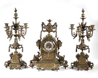 (3pc) G. PHILIPPE FRENCH BRONZE CLOCK GARNITURE | Including a clock, marked "G. Philippe" on the movement, with enameled plaque Roman numeral markers and two four-arm candelabras, all with scrolling acanthus and figural mounts. - l. 15 x w. 6.5 x h. 18.5 in. (clock)