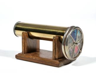 JANICE CHESNIK KALEIDOSCOPE | Handmade brass kaleidoscope signed in 1986 on a conforming wood stand. - l. 6.75 x dia. 3 in.