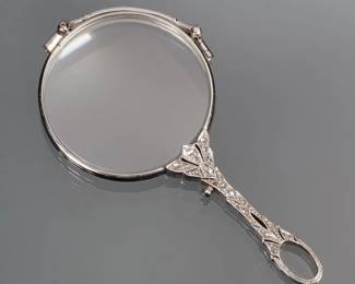 ANTIQUE DIAMOND SET GOLD LORGNETTE | Designed as a 14k white gold lorgnette both sides of the open work handle mounting melee diamonds; marked "585"; 25.5g total weight - l. 3.25 in.

