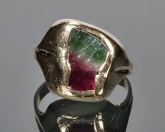 BI-COLOR TOURMALINE & 14K GOLD RING | Designed as a natural amorphous bicolor tourmaline (showing green, a stripe of white, and reddish.purple (approx 10mm. Long) set in a 14k gold surround and ring; size 5, 8.7g