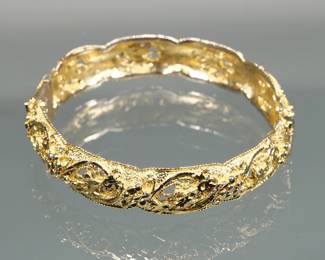 18K GOLD HARD BRACELET | Designed as a hinged hard bracelet decorated with flowers and scrolls pierced open work and a rope work edge hidden box class with safety interior diameter 2.5 in., 30.7 g. Total weight. 
